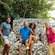 4 tourists posing on a giant seashell chair outside the Nassau Caves in The Bahamas